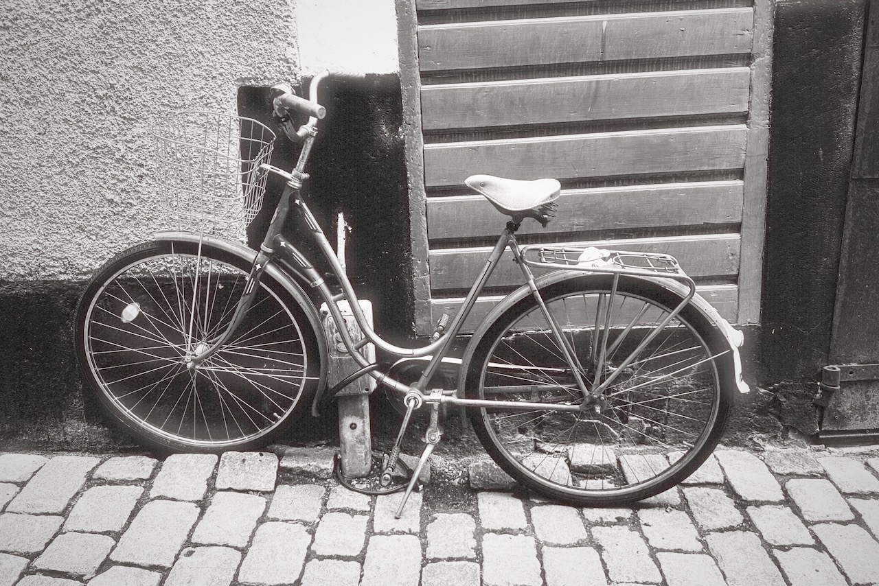 An old bicycle leaning against a wall, shot on 36 Frames Mono 400